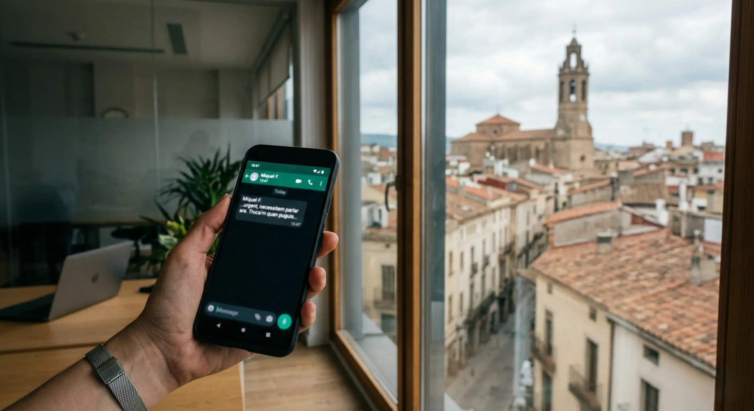 Mano sosteniendo un teléfono móvil con un mensaje de despido por WhatsApp en Granollers